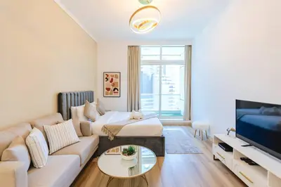 a living room with a couch and a tv at Sunny Studio - Dubai Marina - Close Beach in Dubai