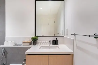 a white kitchen with a sink and a mirror at 3Min to Dubai mall and Burj Khalifa, Luxury 1B and Amenities in Dubai