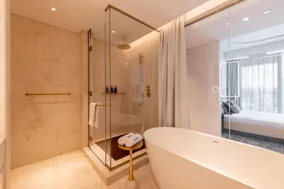 a bathroom with a tub and a bedroom at Exclusive 2BR Residence on Palm Jumeirah - Beach Access in Dubai