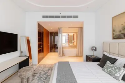 a bedroom with a bed and a television and a bathroom at Exclusive 2BR Residence on Palm Jumeirah - Beach Access in Dubai