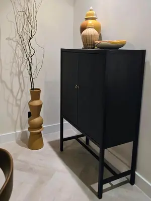 a black cabinet with a vase on top of it at Top Floor Penthouse In Oceana With Panoramic Views in Dubai