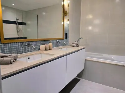 a bathroom with a sink and a mirror and a tub at Top Floor Penthouse In Oceana With Panoramic Views in Dubai