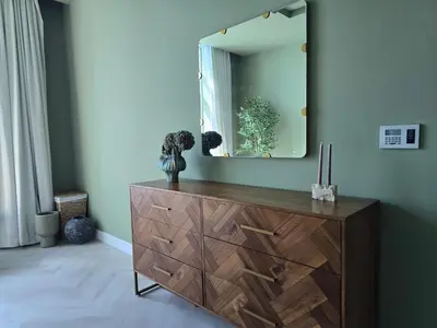 a dresser with a mirror on top of it at Top Floor Penthouse In Oceana With Panoramic Views in Dubai