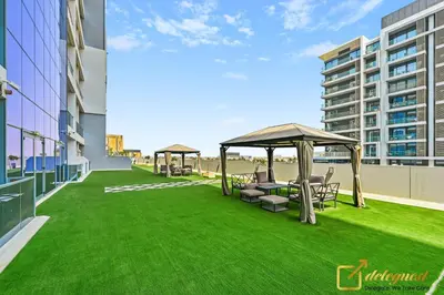 a lawn with chairs and a gazebo on a building at Elite Studio in Dubai Hills Near Dubai Hills Mall in Dubai