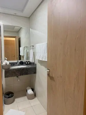 a bathroom with a sink and a wooden door at Flat 1BR Business Bay the bay in Dubai