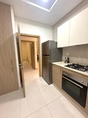 a kitchen with a refrigerator and a stove top oven at Flat 1BR Business Bay the bay in Dubai