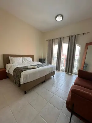 a bedroom with a bed and a couch and windows at Executive Master bed Room With attached bathroom in Dubai