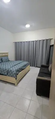 a bedroom with a bed and a couch in it at Luxury Master Bed Room With Attached Bathroom in Dubai
