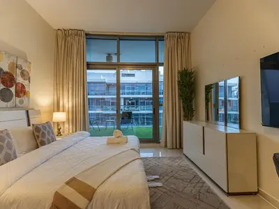 a bedroom with a bed and a large window at Spacious Golf & Pool View Home with Huge Balcony in Dubai