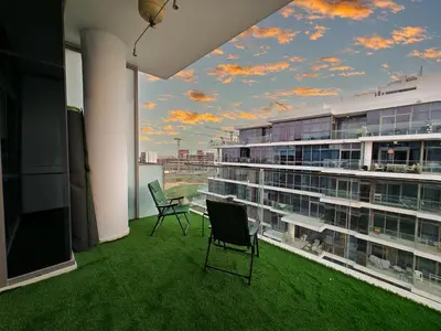 a balcony with chairs and a view of a building at Spacious Golf & Pool View Home with Huge Balcony in Dubai