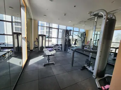 a gym with treadmills and machines in a building at Spacious Golf & Pool View Home with Huge Balcony in Dubai