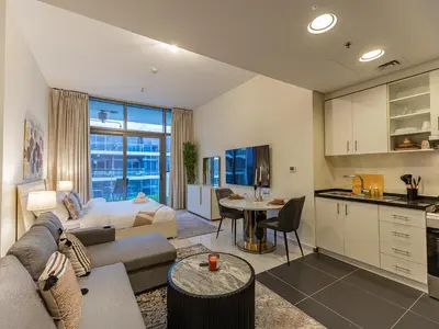 a living room with a couch and a table at Spacious Golf & Pool View Home with Huge Balcony in Dubai