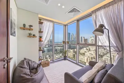 a living room with a couch and a large window at Nonna house Stylish 1BR and Panoramic Studio, City, Golf, Lake view in Dubai