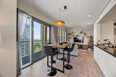 a kitchen and living room with a table and chairs at Nonna house Stylish 1BR and Panoramic Studio, City, Golf, Lake view in Dubai