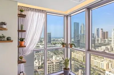 a large window with views of the city at Nonna house Stylish 1BR and Panoramic Studio, City, Golf, Lake view in Dubai