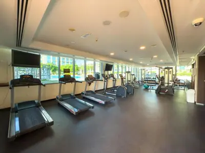a gym with a row of treadmills in a room at Nonna house Stylish 1BR and Panoramic Studio, City, Golf, Lake view in Dubai