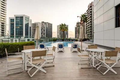 a rooftop patio with tables and chairs and a pool at Luxury Stunning Burj Khalifa View High Floor Big Balcony Pool&Gym 1BR 80m2 in Dubai