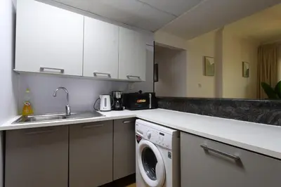 a kitchen with a sink and a washing machine at Luxury 2BHK In Marina W Rooftop Pool Man 1908 in Dubai