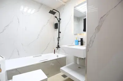 a white bathroom with a sink and a mirror at Luxury 2BHK In Marina W Rooftop Pool Man 1908 in Dubai
