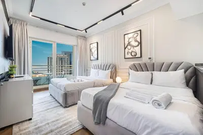 a hotel room with two beds and a television at Lux 3 Bedroom Apt In Dubai Marina Man 2003 in Dubai