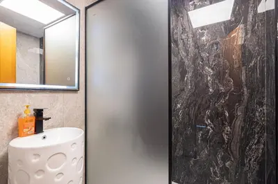 a bathroom with a shower with a sink and a mirror at Lux 3 Bedroom Apt In Dubai Marina Man 2003 in Dubai