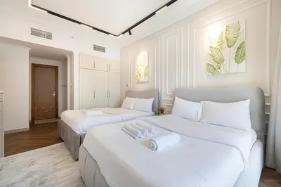 two beds in a room with white walls at Lux 3 Bedroom Apt In Dubai Marina Man 2003 in Dubai