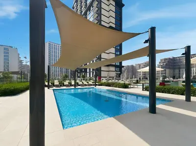 a swimming pool in a city with a building at New Elegant 1BR with Balcony & Pool in Park Field in Dubai