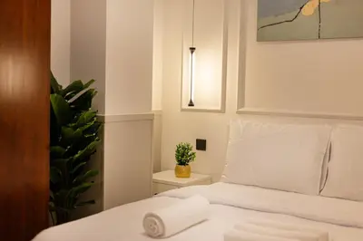 a bedroom with a bed with white sheets and a plant at Luxury 2BHK in Dubai Marina Escan 2001 in Dubai