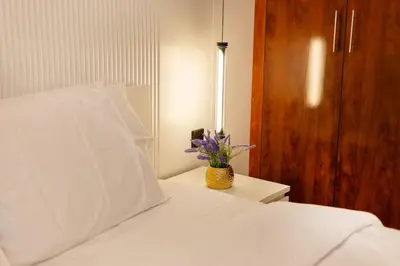 a bedroom with a white bed with a vase of flowers at Luxury 2BHK in Dubai Marina Escan 2001 in Dubai