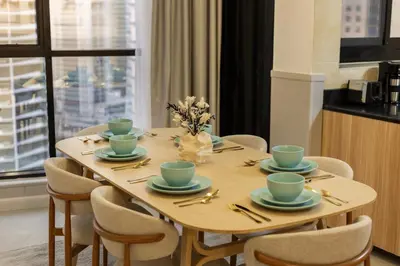 a dining room table with chairs and a table with cups at Luxury 2BHK in Dubai Marina Escan 2001 in Dubai