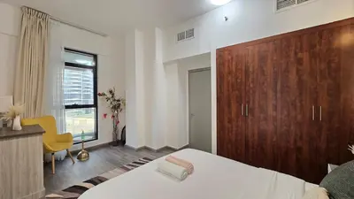 a bedroom with a bed and a wooden cabinet at Luxury 2BHK in Dubai Marina Escan 402 in Dubai