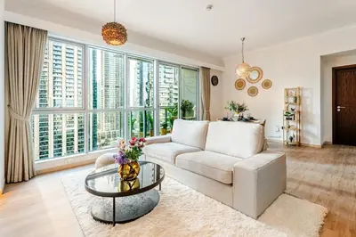 a living room with a white couch and a glass table at Cozy 1BR Near Burj Khalifa and Dubai Mall in Dubai