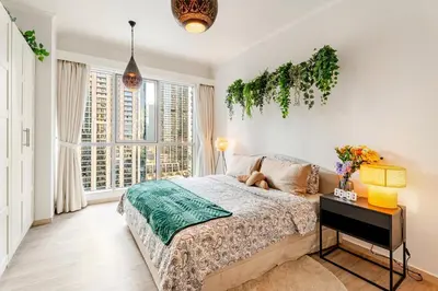 a bedroom with a bed and a table with a plant at Cozy 1BR Near Burj Khalifa and Dubai Mall in Dubai