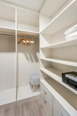 a walk in closet with white walls and shelves at Cozy 1BR Near Burj Khalifa and Dubai Mall in Dubai