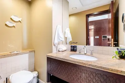 a bathroom with a sink and a toilet and a mirror at Cozy 1BR Near Burj Khalifa and Dubai Mall in Dubai
