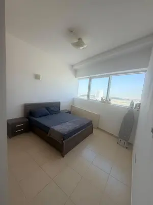 a bedroom with a bed and a large window at Stunning Furnished 3-Bedroom Apartment in Dubai