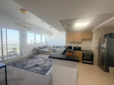 a kitchen and living room with a couch and a refrigerator at Stunning Furnished 3-Bedroom Apartment in Dubai