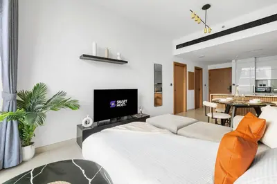 a living room with two beds and a tv at New! Lovely 1BR with Balcony & Pool in Binghatti Orchid in Dubai