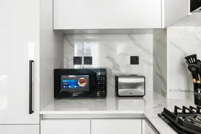 a microwave oven sitting on top of a kitchen counter at New! Lovely 1BR with Balcony & Pool in Binghatti Orchid in Dubai