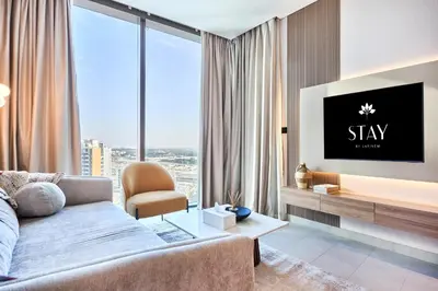 a living room with a couch and a tv at STAY BY LATINEM Luxury 1BR plus study Holiday Home W2405 in Dubai
