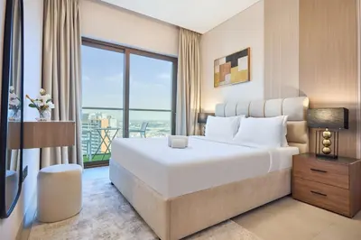 a bedroom with a large bed and a large window at STAY BY LATINEM Luxury 1BR plus study Holiday Home W2405 in Dubai