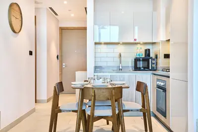 a kitchen and dining room with a table and chairs at STAY BY LATINEM Luxury 1BR plus study Holiday Home W2405 in Dubai