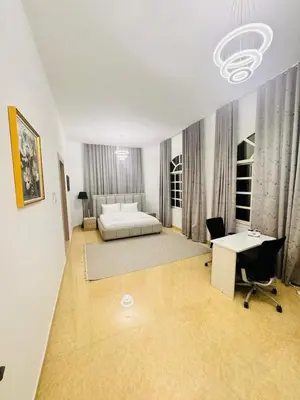 a bedroom with a bed and a desk and a table at Luxe Villa Rooms in Dubai