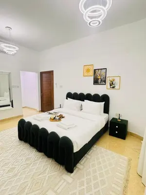 a large bed with a black tufted headboard in a bedroom at Luxe Villa Rooms in Dubai