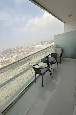 a balcony with tables and chairs and a view of the beach at Studio in Dubai
