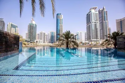 a large swimming pool in a city with tall buildings at HAVN - 2 bedroom in Marina with Dubai Marina View in Dubai