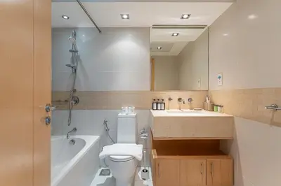 a bathroom with a sink and a toilet and a mirror at HAVN - 2 bedroom in Marina with Dubai Marina View in Dubai