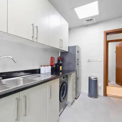 a kitchen with a sink and a washing machine at Dunya Tower in Dubai