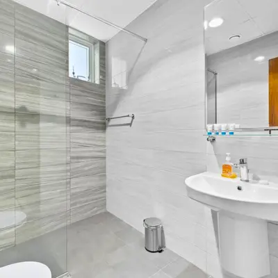 a bathroom with a sink and a glass shower at Dunya Tower in Dubai