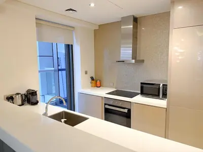 a kitchen with a sink and a stove top oven at Cozy 2BR in Paramount Dubai with Burj Khalifa View in Dubai